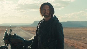 Sebastian Stan stands in front of a motorcycle on a desert road in a still from Thunderbolts* movie