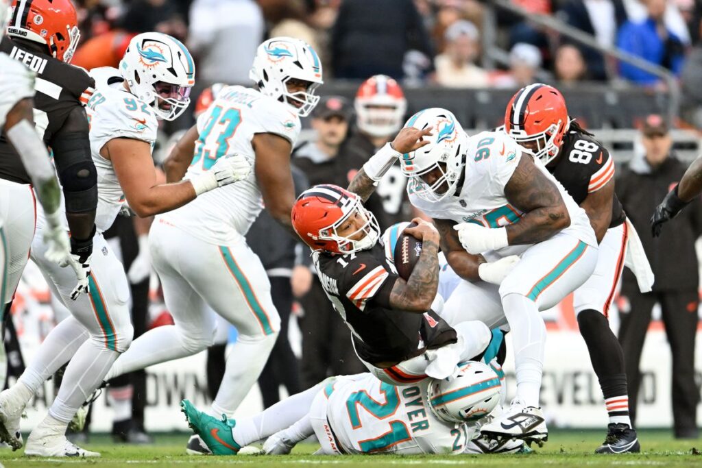 Dorian Thompson-Robinson #17 of the Cleveland Browns is tackled by Jordan Poyer #21 and Da'Shawn Hand #90 of the Miami Dolphins during the first quarter at Huntington Bank Field on December 29, 2024