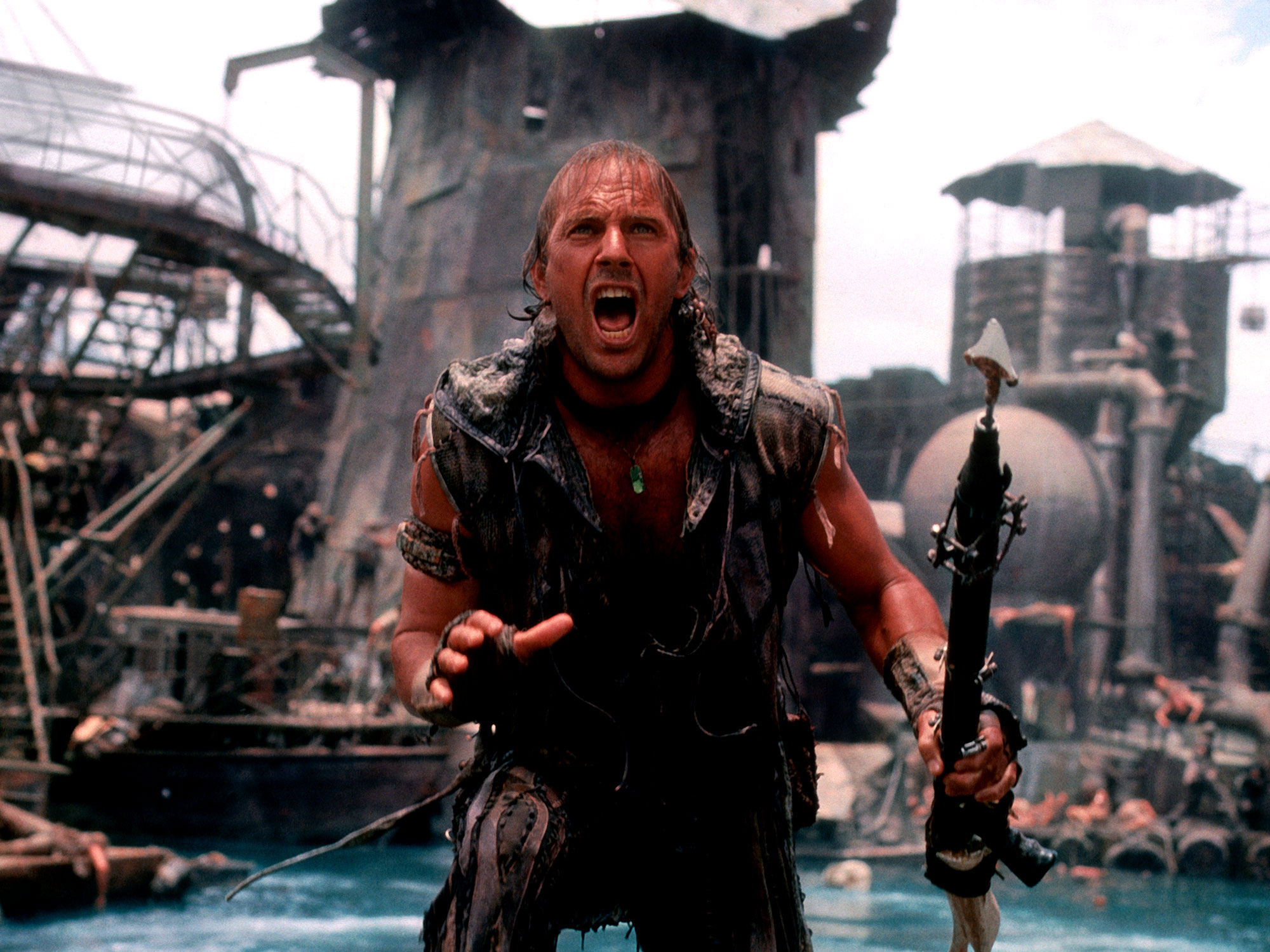 Kevin Costner holding a harpoon and shouting in Waterworld.