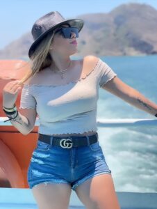 Woman in hat and sunglasses on a boat.