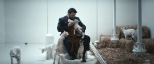 Wyatt, the Goat Wrangler, feeds a baby goat in a still from Severance season 1