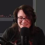 Streamer smiling while using a microphone.