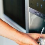 hand getting water from fridge