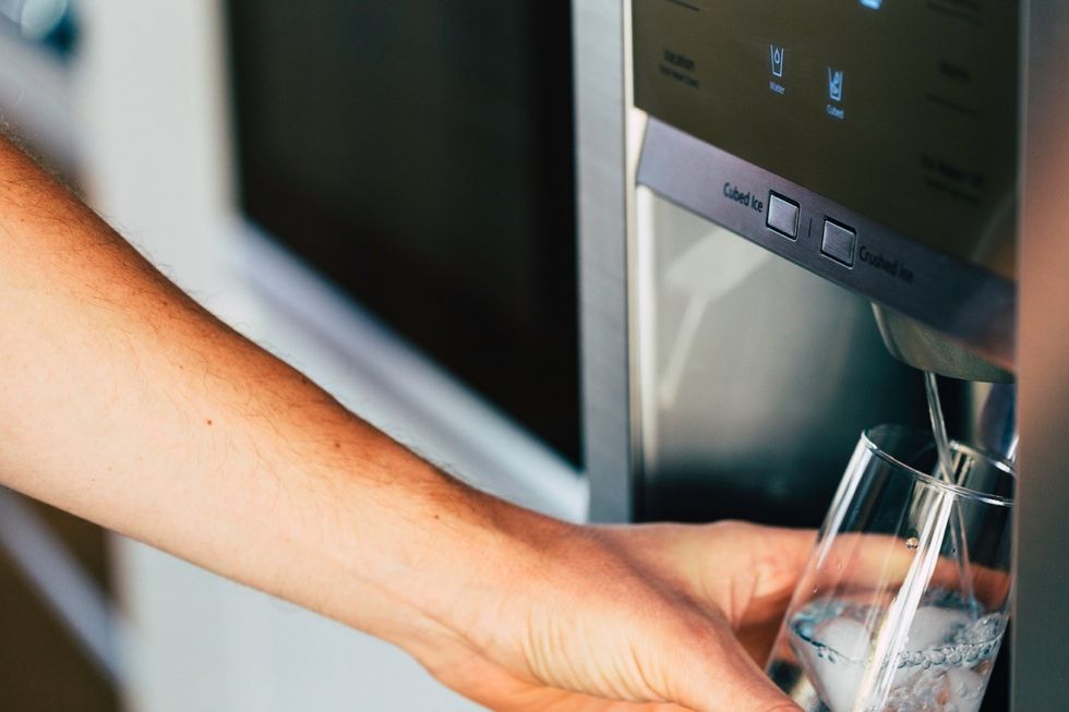 hand getting water from fridge