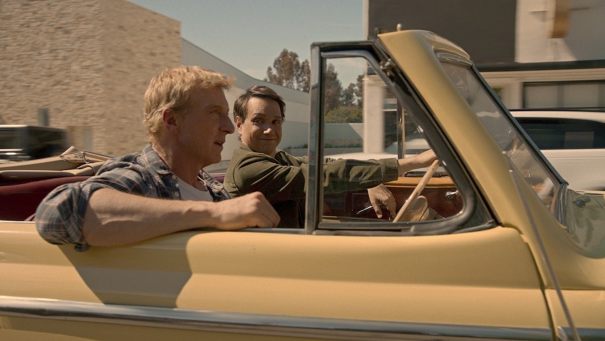 Johnny and Daniel driving in a yellow convertible on Cobra Kai