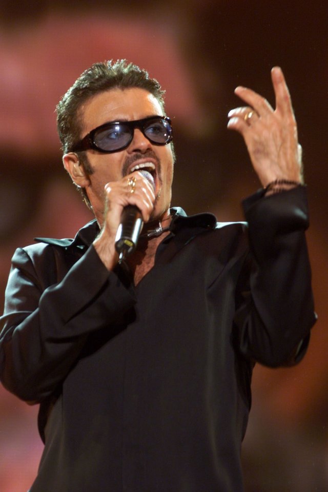 George Michael performing at a concert.