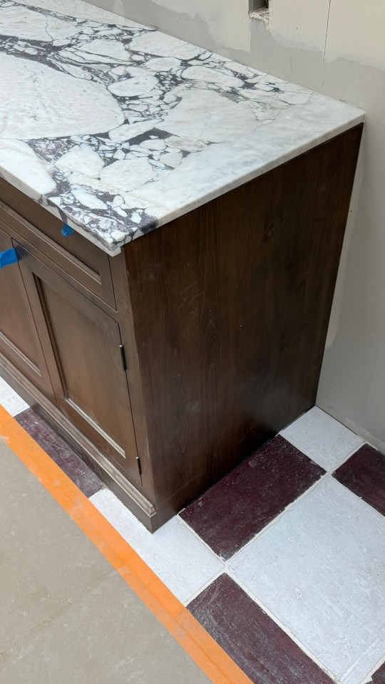 Dark brown cabinet with marble countertop.