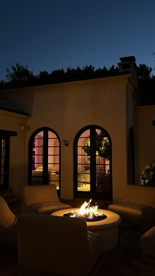 Kendall Jenner's home at night, showing a fire pit and patio furniture.