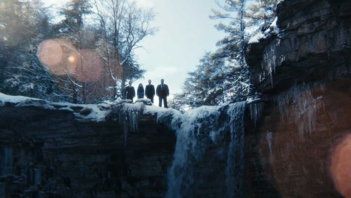 Four people standing atop a waterfall on Severance