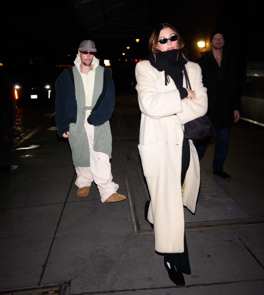 Justin and Hailey Bieber walking at night in New York City.