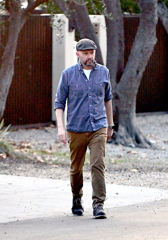 Jon Cryer walking down a residential street.