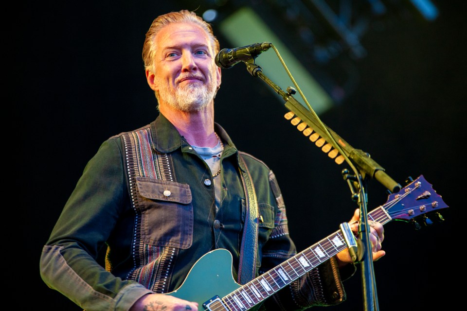 a man playing a guitar and singing into a microphone