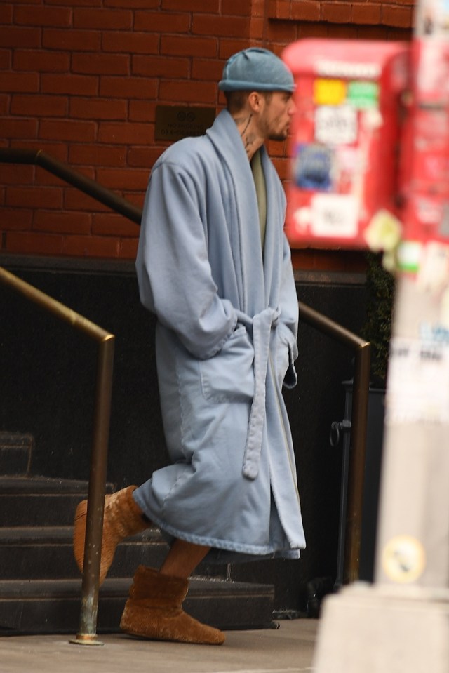 Justin Bieber wearing a light blue robe and brown slippers in NYC.