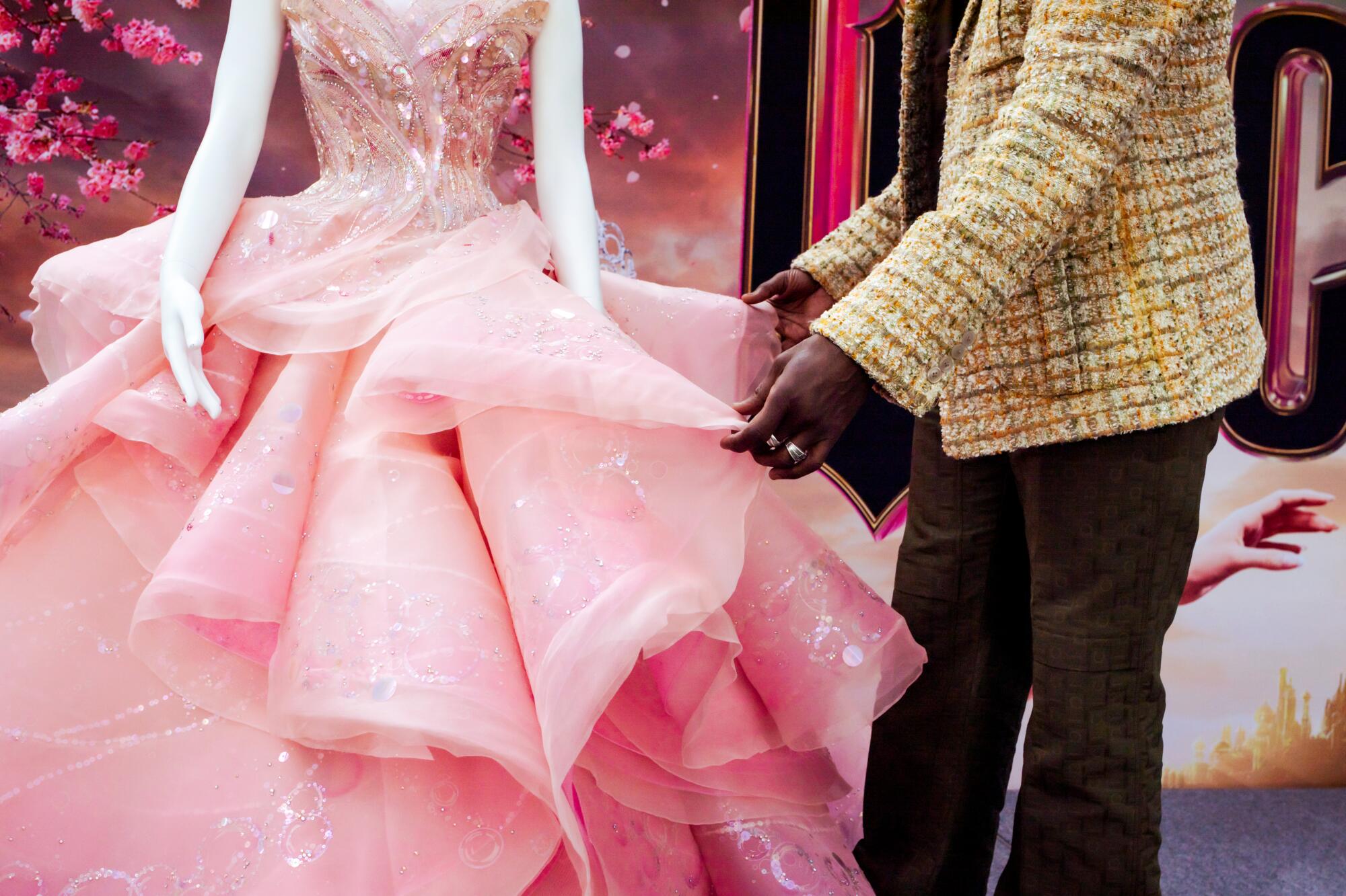 Costume designer Paul Tazewell shows off a sparkly pink gown from the film.