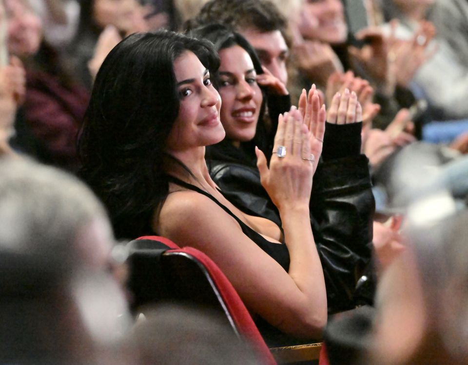 Kylie Jenner and another woman clapping at an awards ceremony.