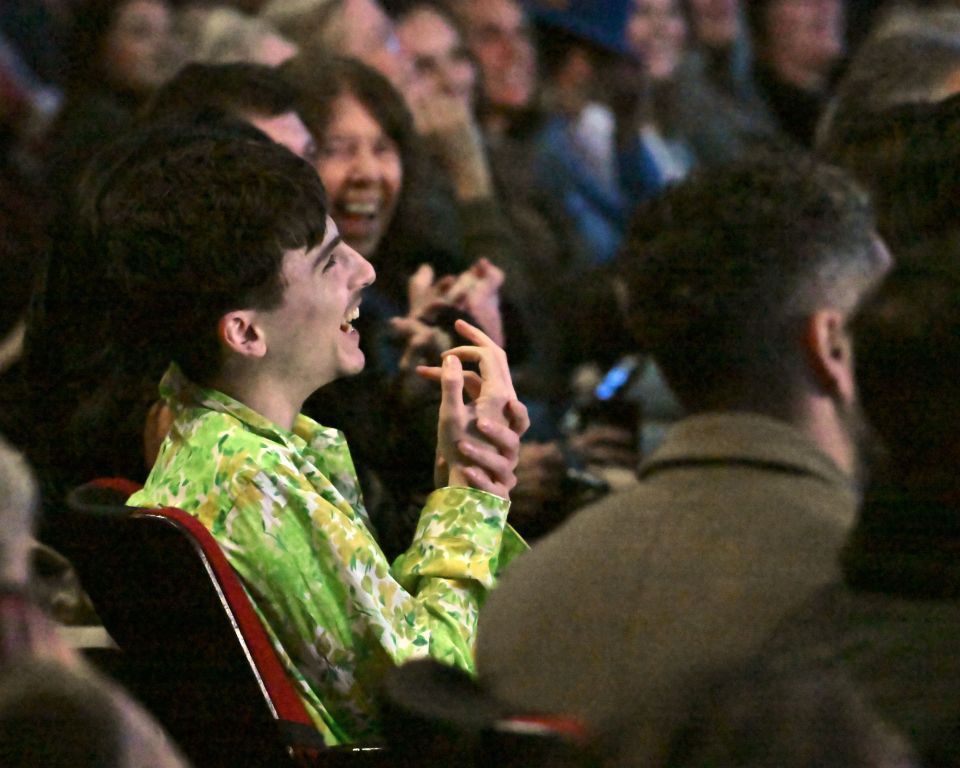 Person laughing in a crowd at an awards ceremony.