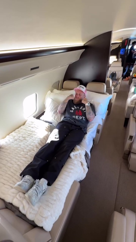 Jake Paul lying on a bed in a private jet.