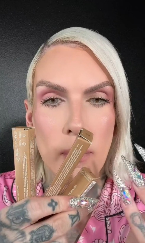 Person holding three tubes of lip gloss.