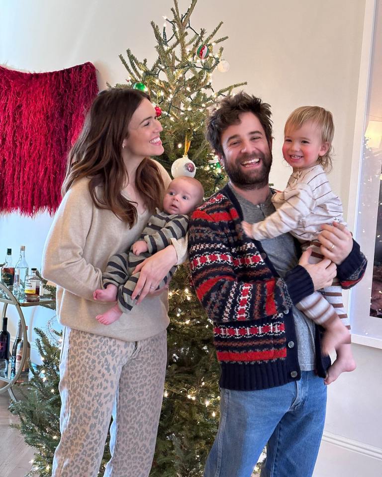 Mandy Moore, Taylor Goldsmith, and their two children by a Christmas tree.