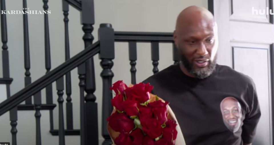 Lamar Odom holding red roses in a trailer for The Kardashians.