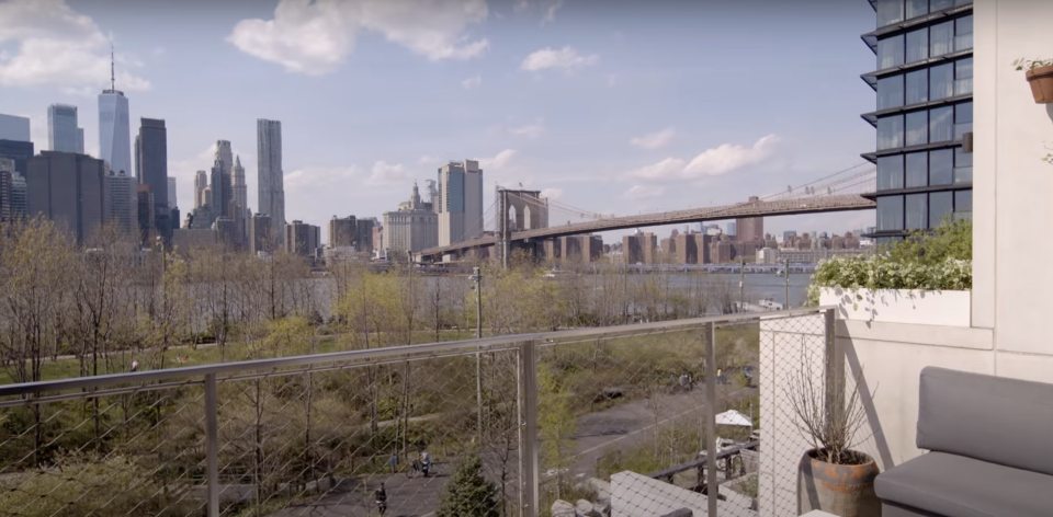 View of the Manhattan skyline and the Brooklyn Bridge from a balcony.