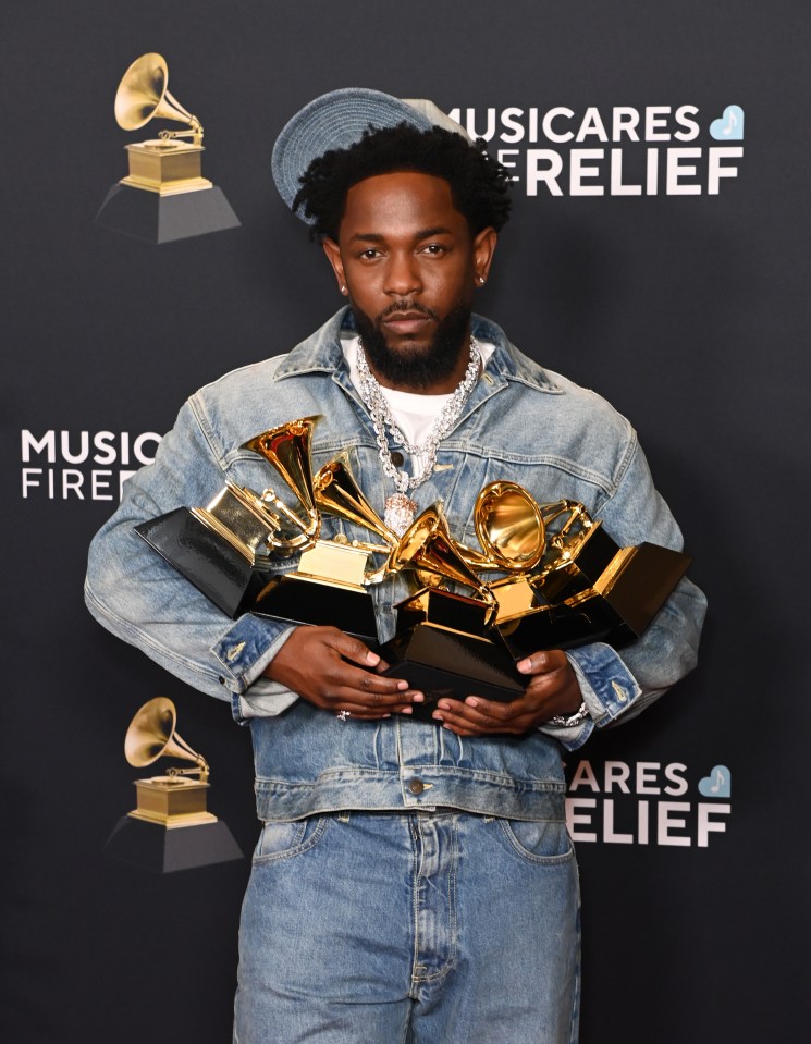 Kendrick Lamar holding multiple Grammy Awards.