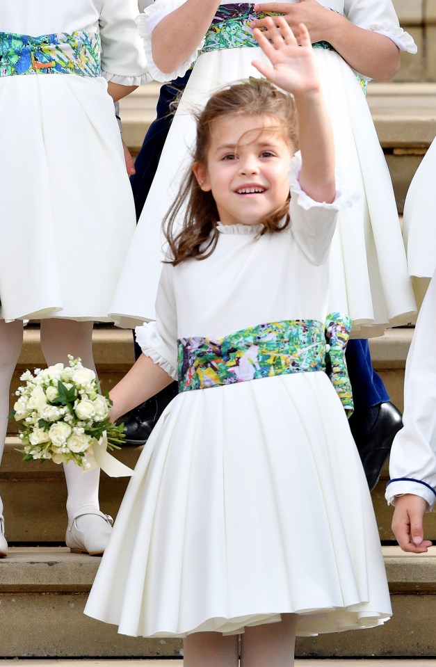 Girl in white dress waving at Princess Eugenie's wedding.