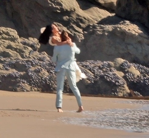 Kim Kardashian and Matthew Noszka on a beach during a wedding scene for the TV show "All's Fair".