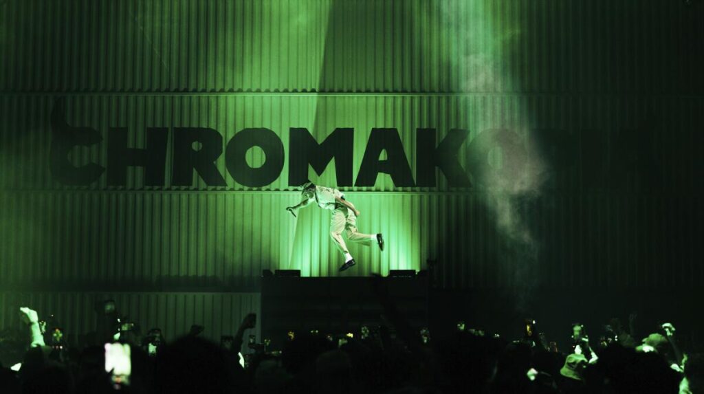 Tyler, the Creator leaps against a green background with the word "Chromakopia" in large black capital lettering