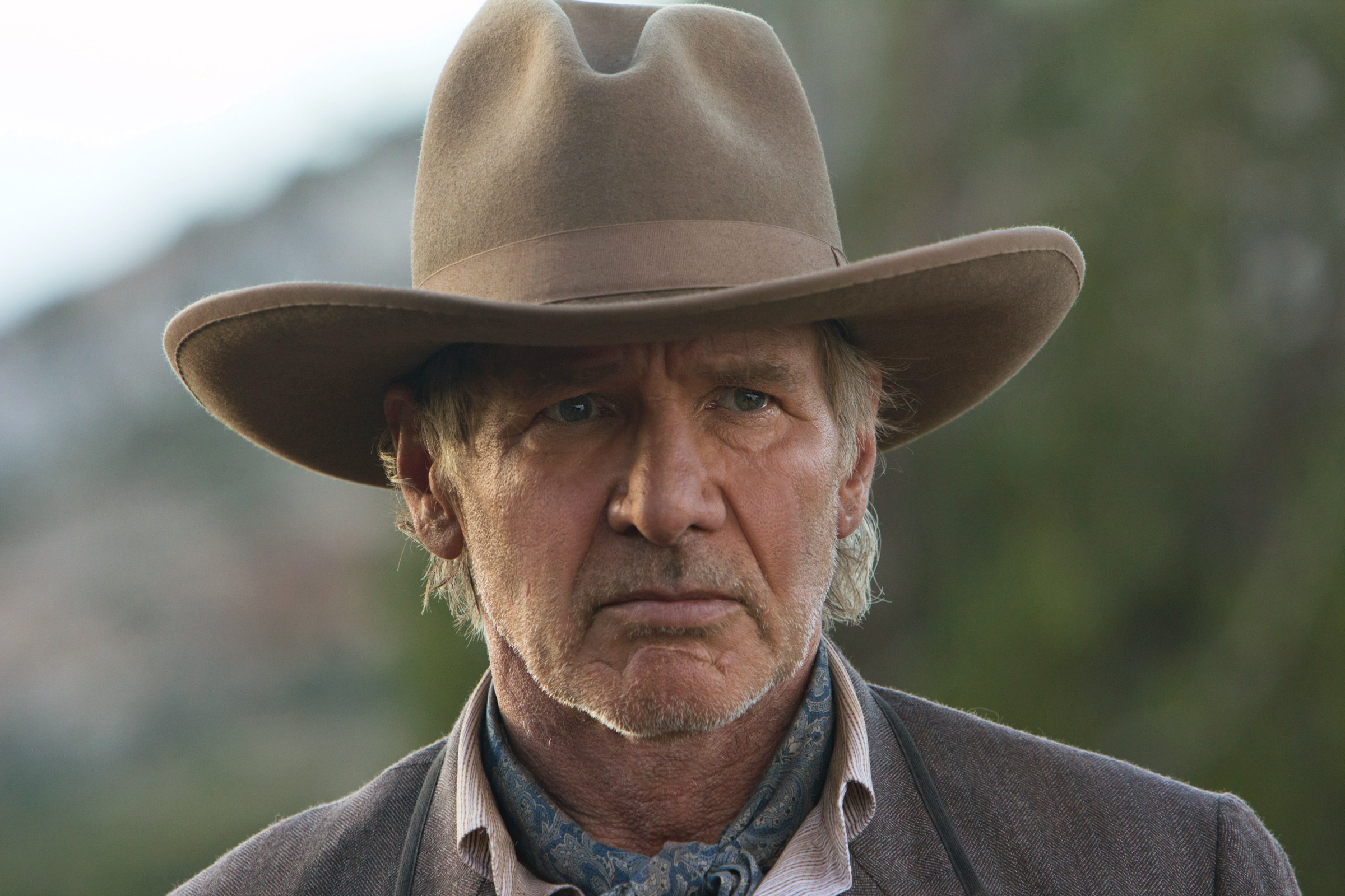 Harrison Ford in a cowboy hat looking angry in Cowboys & Aliens