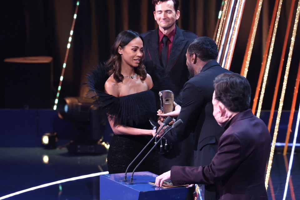 Zoe Saldaña accepting a Supporting Actress award.