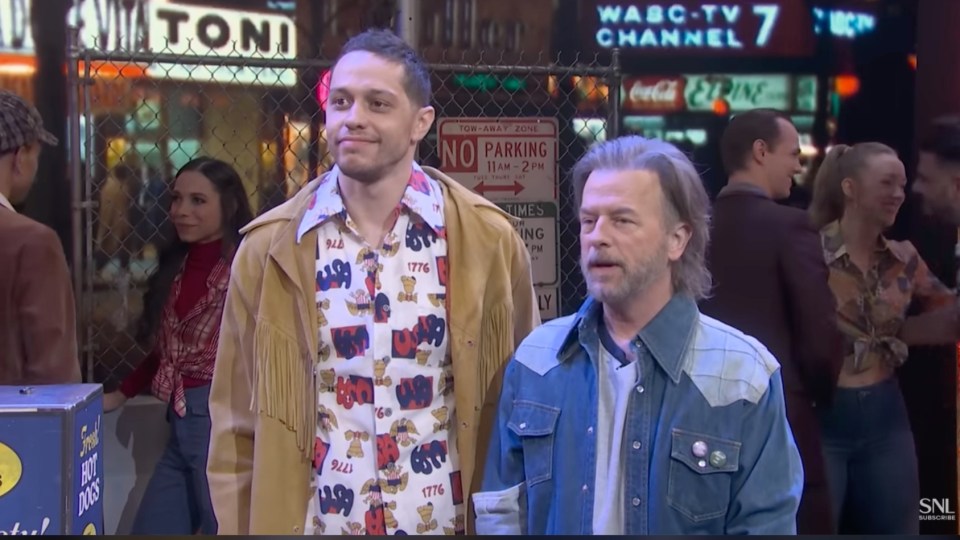 Pete Davidson and another man in 1970s attire at an SNL party.