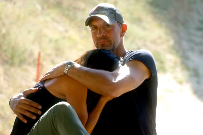 Man comforting a woman outdoors.