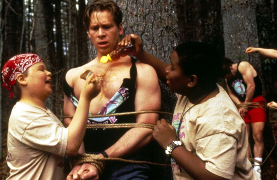 Still from Heavyweights (1995) showing a tied-up camper having honey poured on his chest by two other campers.