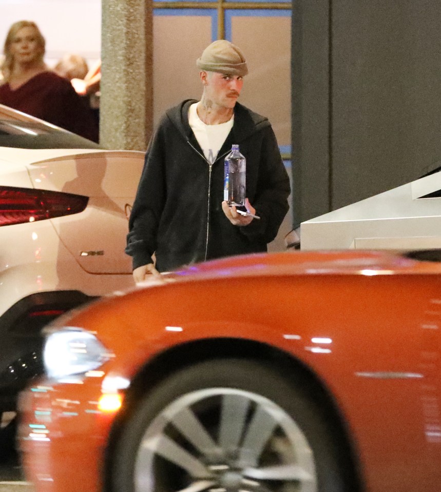 Justin Bieber leaving a spa, holding a water bottle.