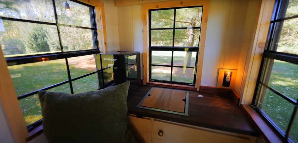 Tiny home interior with a small countertop, cutting board, and water cooler.