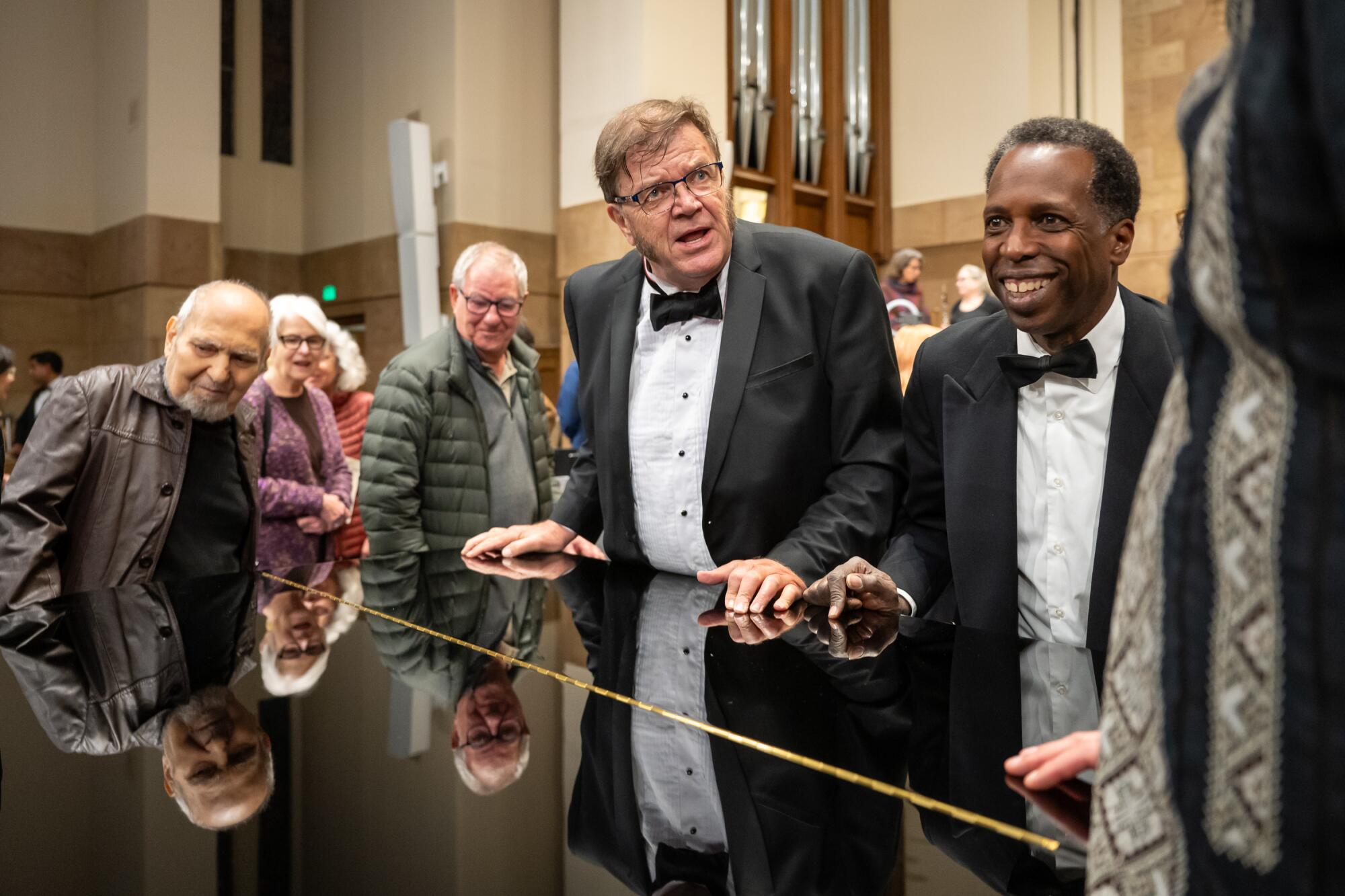 Violinist Ingemar Hulthage, center, who lost his home in the Palisades Fire, moves a piano with violist David Quinn.