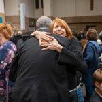 Debbie Rafei hugs her cousin who lost his home in the Palisades Fire, during intermission.