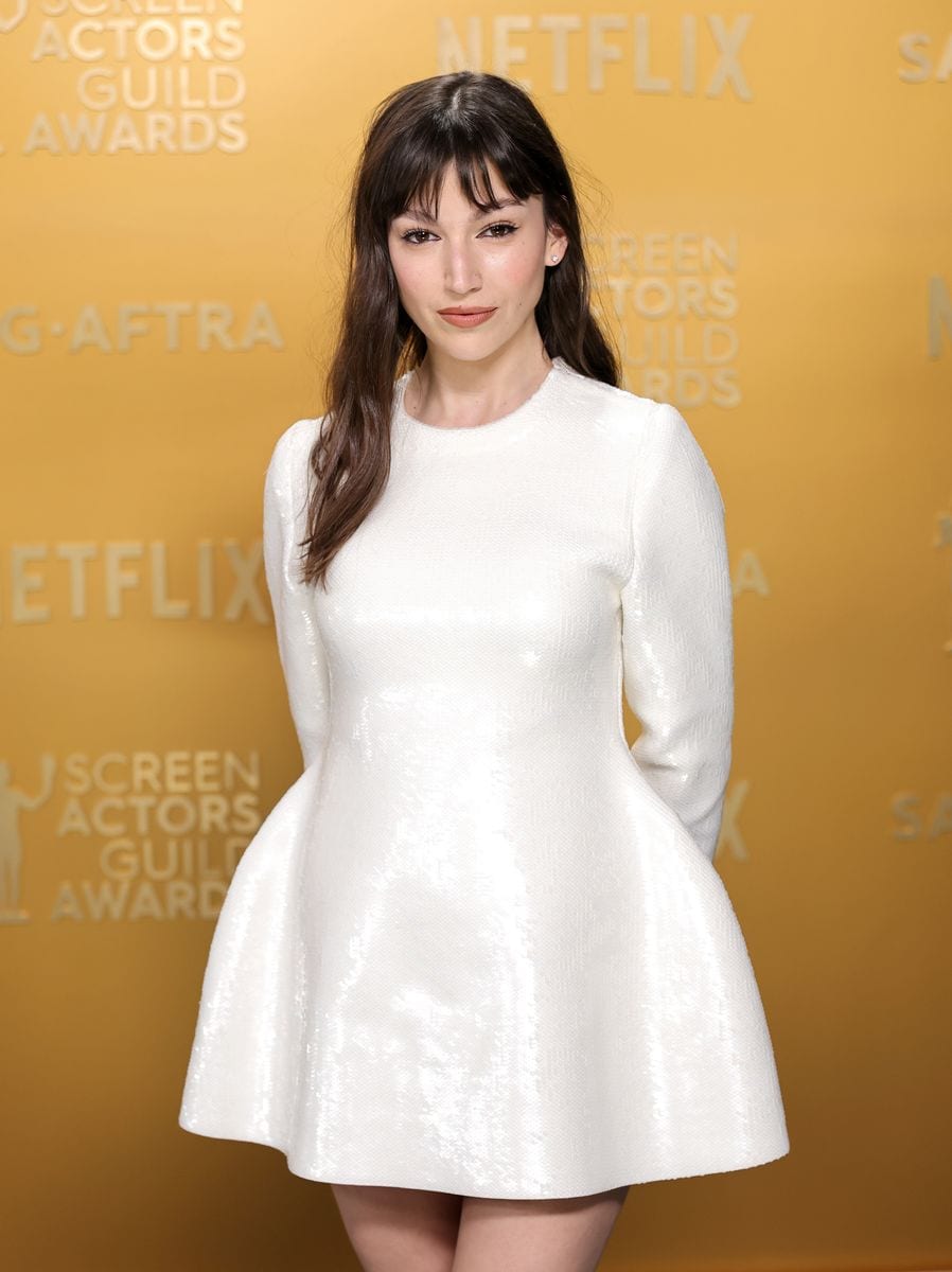 Úrsula Corberó wearing a white long-sleeve Loewe dress on the SAG Awards 2025 red carpet.