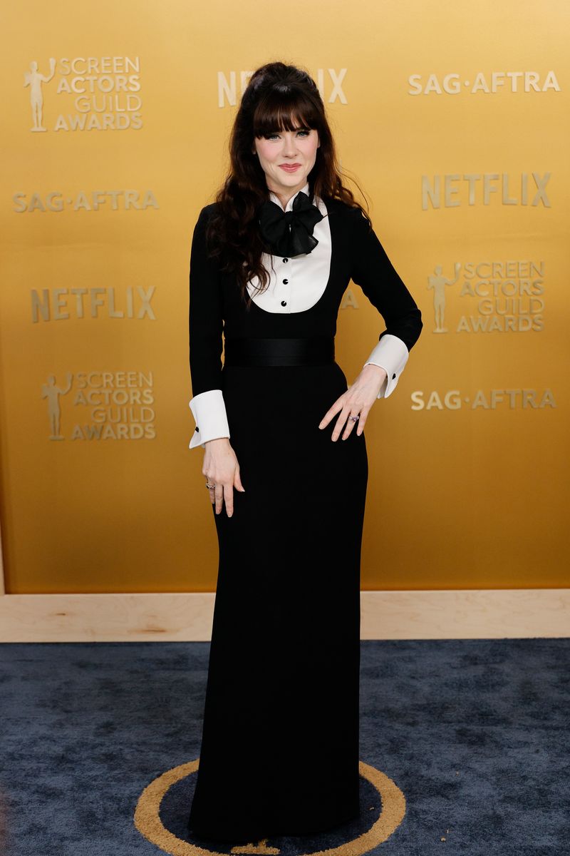 Zooey Deschanel embraces vintage elegance in a Giorgio Armani tuxedo-inspired gown at the SAG Awards 2025, paired with Gianvito Rossi heels and Lagos jewelry.