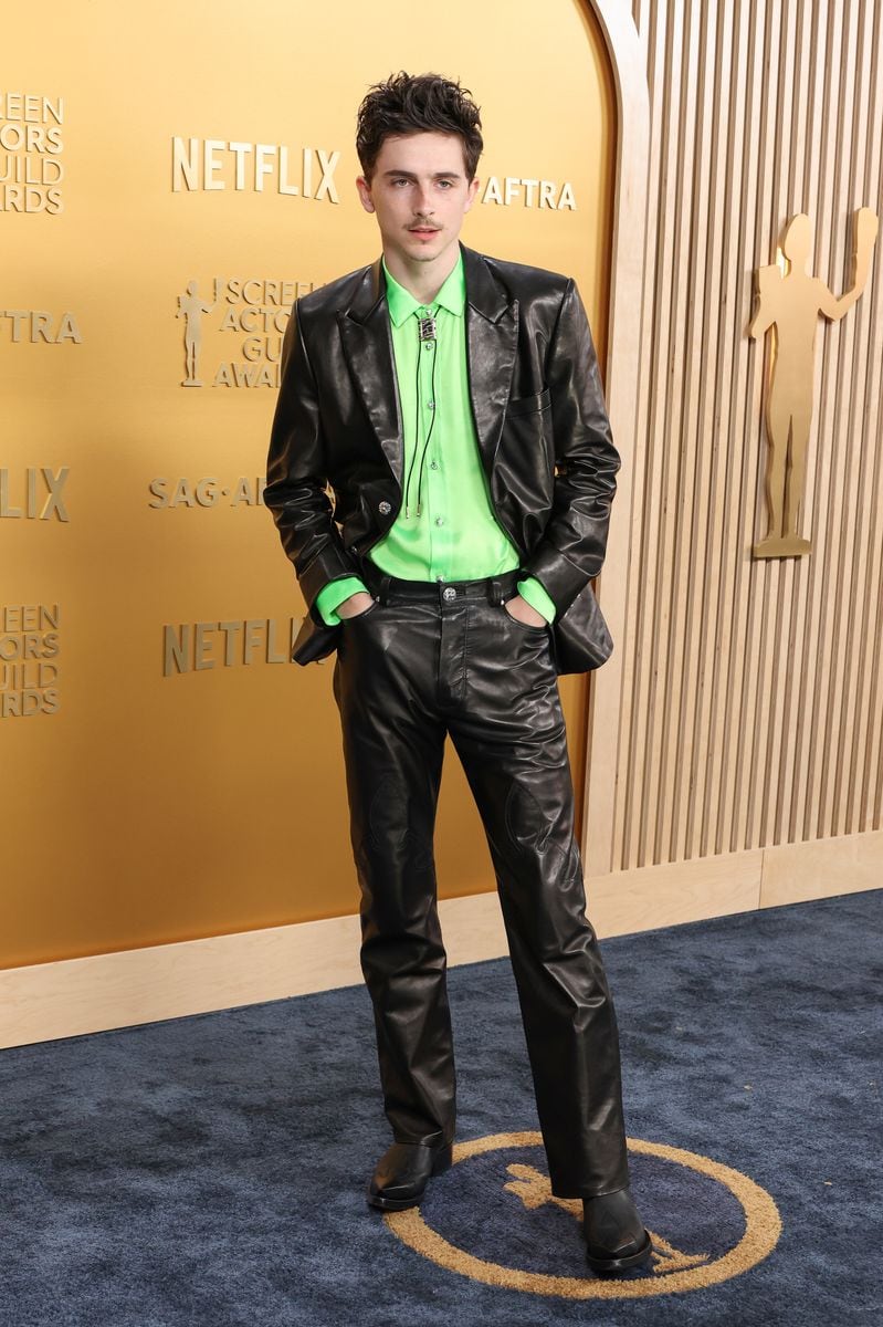 Timothée Chalamet wearing a black Chrome Hearts leather suit with a neon green shirt and Western-inspired bolo tie at the SAG Awards 2025.