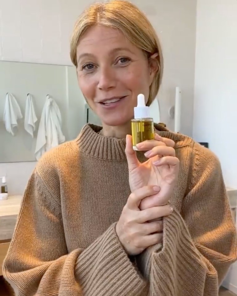 Gwyneth Paltrow holding a bottle of goop face oil.