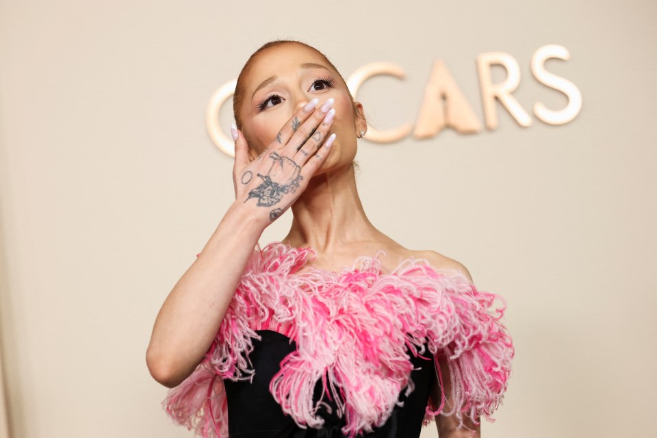 Ariana Grande at the Oscars, covering her mouth with her hand.