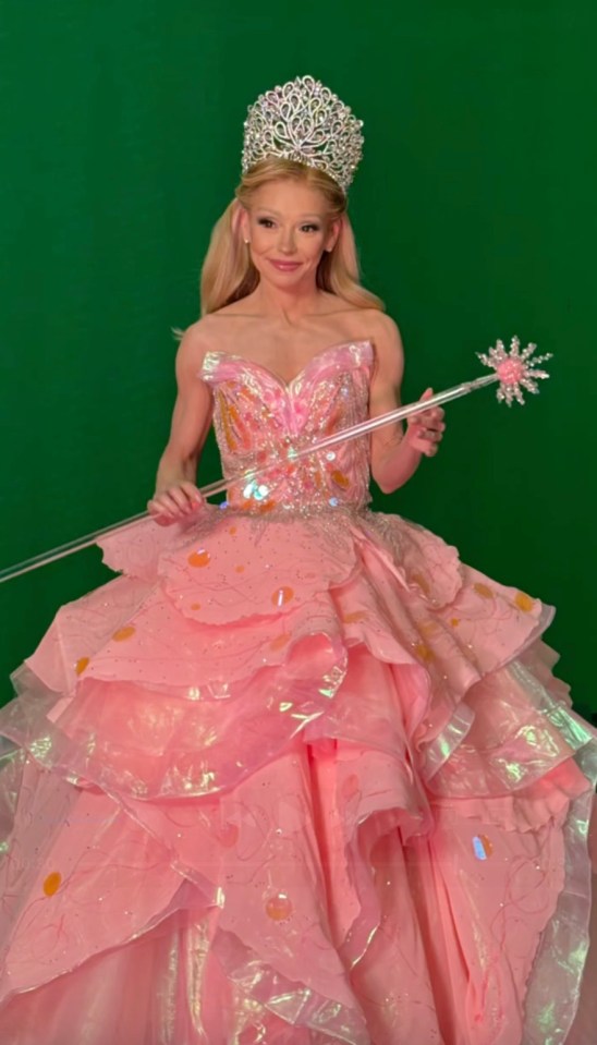 Kelly Ripa in a pink princess gown and crown, holding a wand.