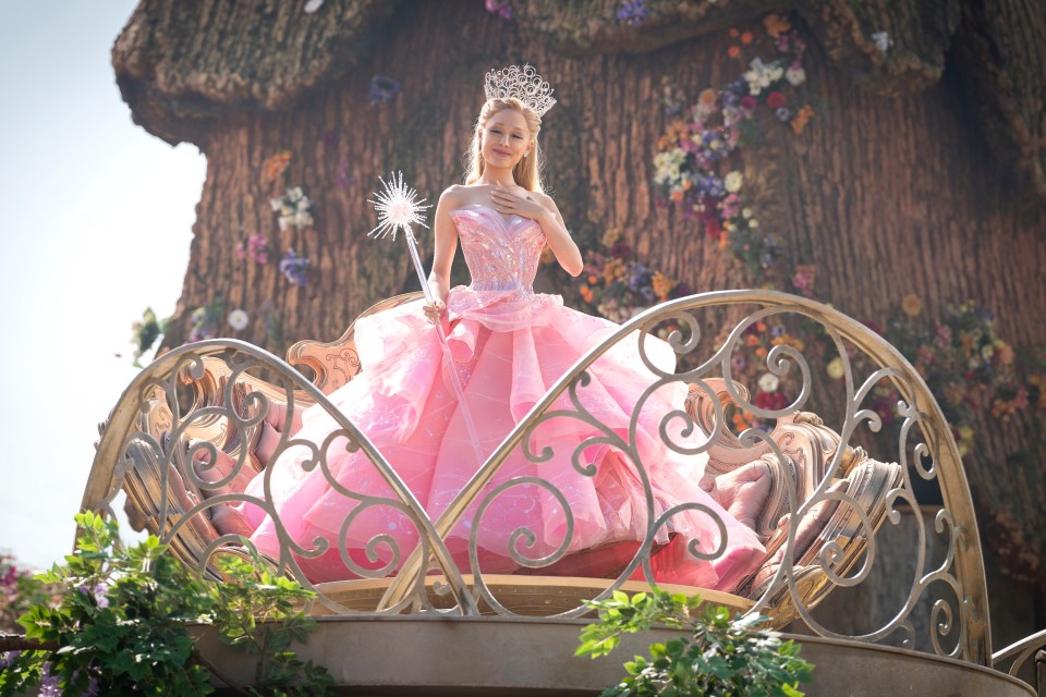 Ariana Grande in a pink gown and crown in a scene from the film "Wicked."