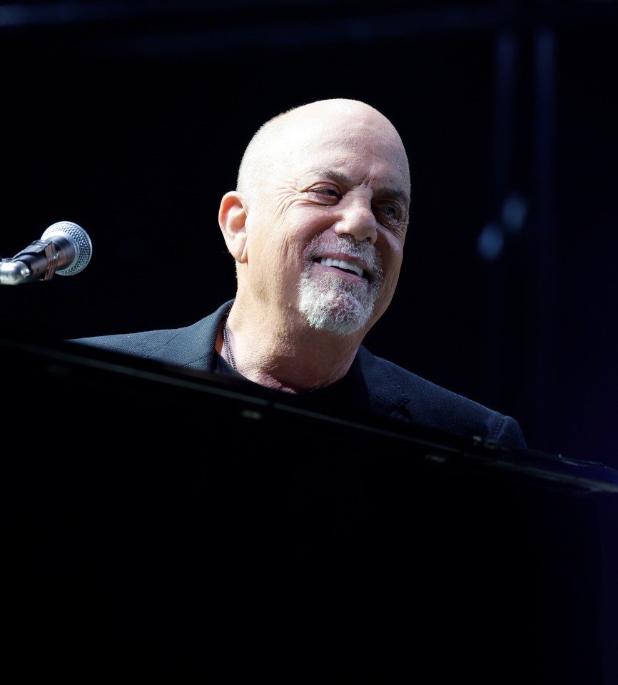 Billy Joel performing at a concert.