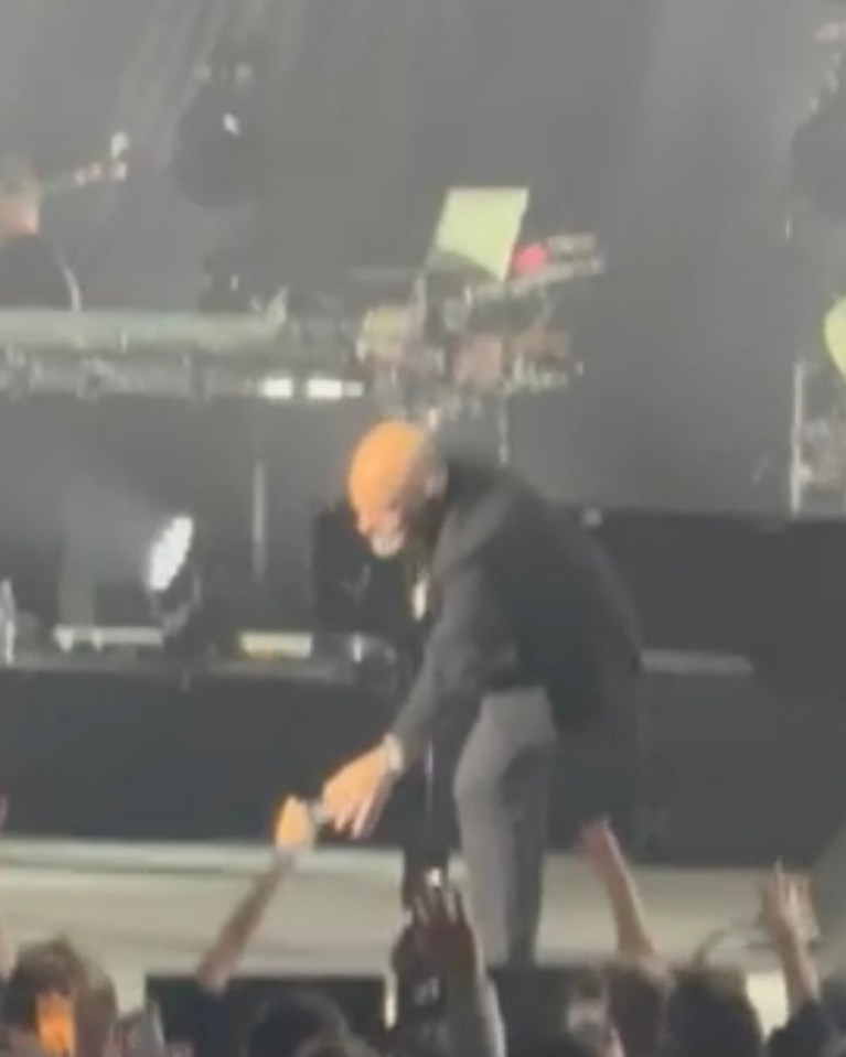 Billy Joel falling on stage during a concert.