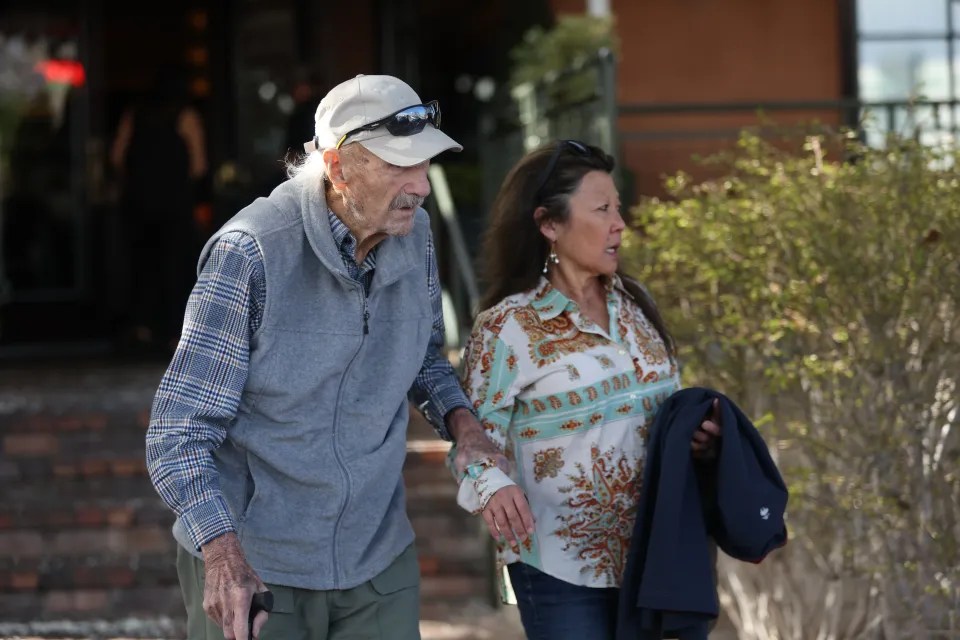 Older man walking with a woman.