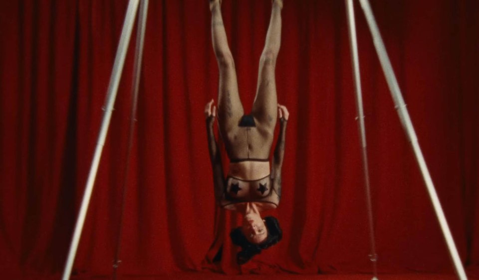 Halsey hanging upside down in a music video.