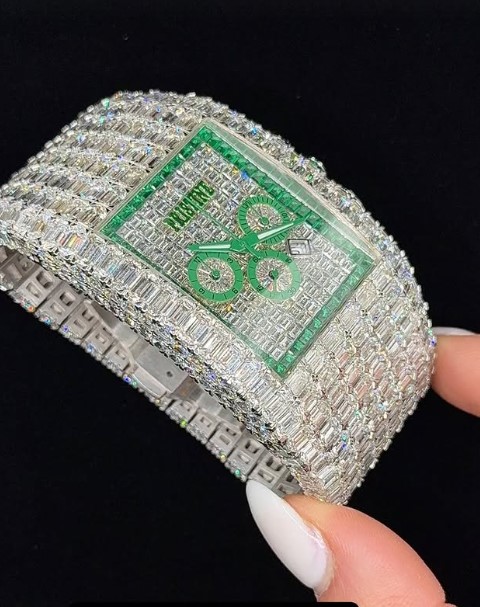 Diamond-encrusted watch with green face.